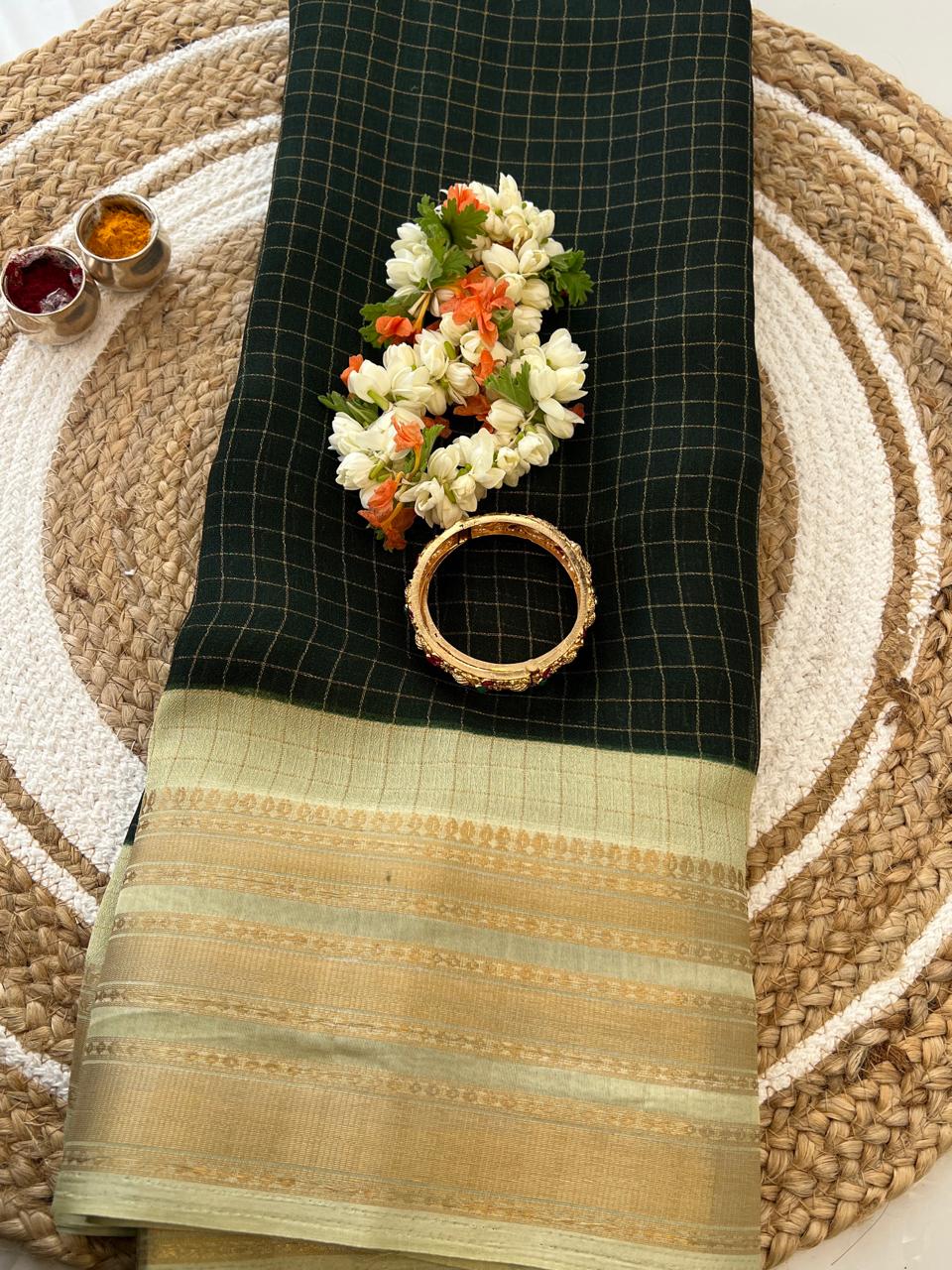 Bottle green saree folded with jasmine flowers and bangle styling