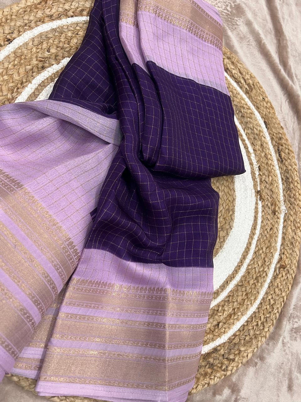 Purple and lavender saree folded on rattan plate close-up