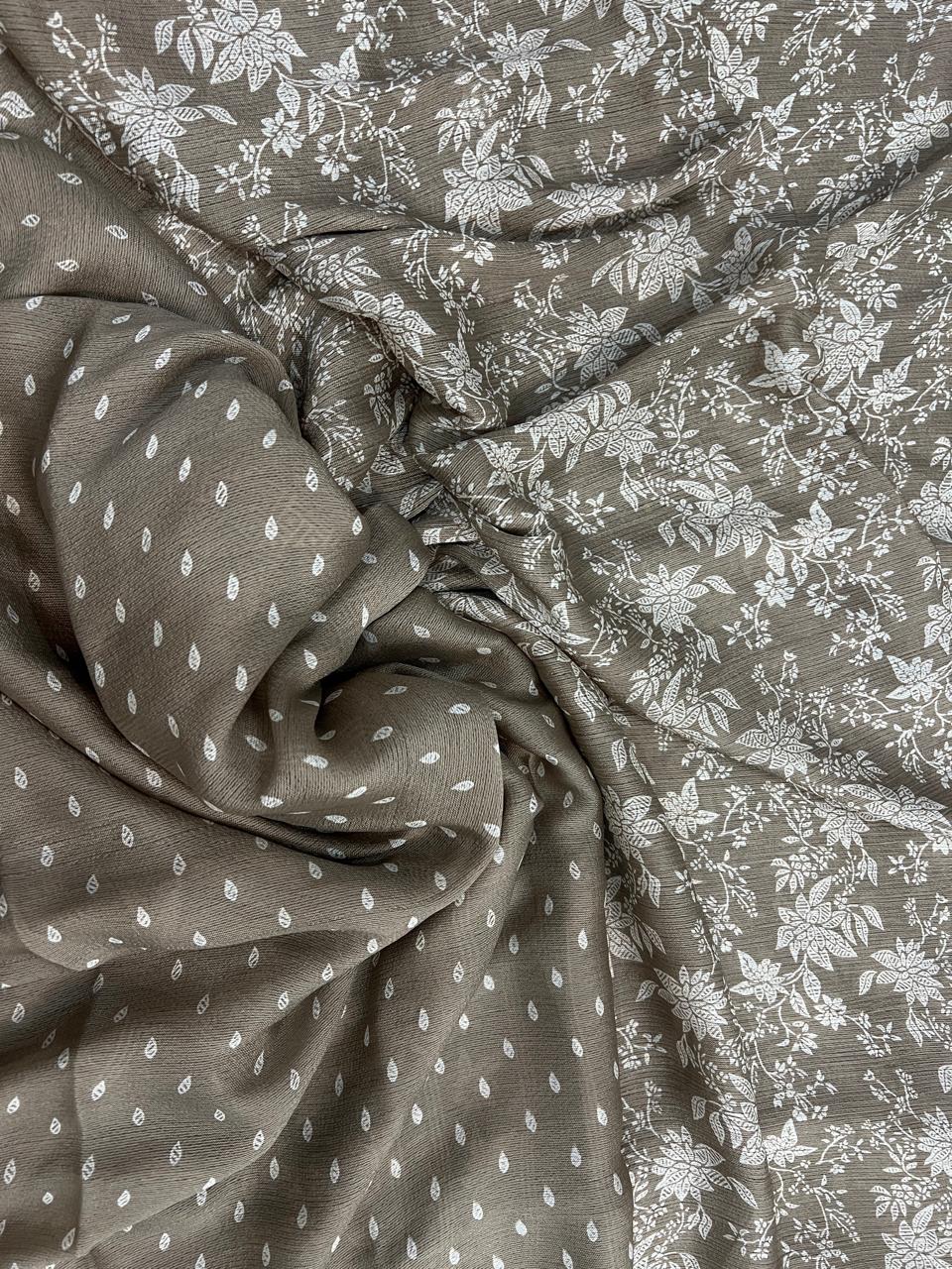 Taupe grey saree flat lay close-up showing white botanical floral print and teardrop leaf scatter on pallu