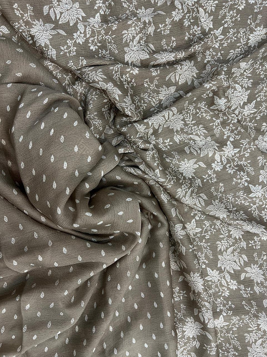Taupe grey saree flat lay close-up showing white botanical floral print and teardrop leaf scatter on pallu