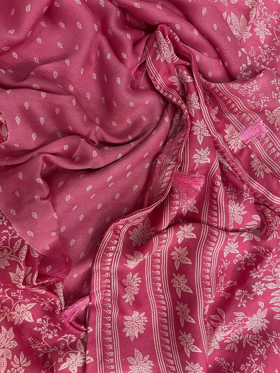 Rose pink saree flat lay close-up showing white botanical floral print and woven striped border with tassels