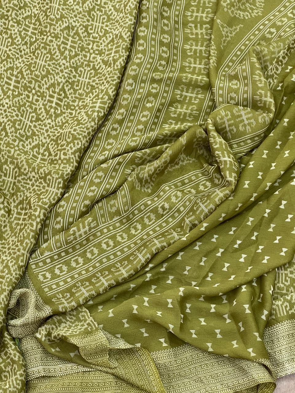 Olive green ikat tribal geometric print saree flat lay showing all-over cream medallion print and chevron border