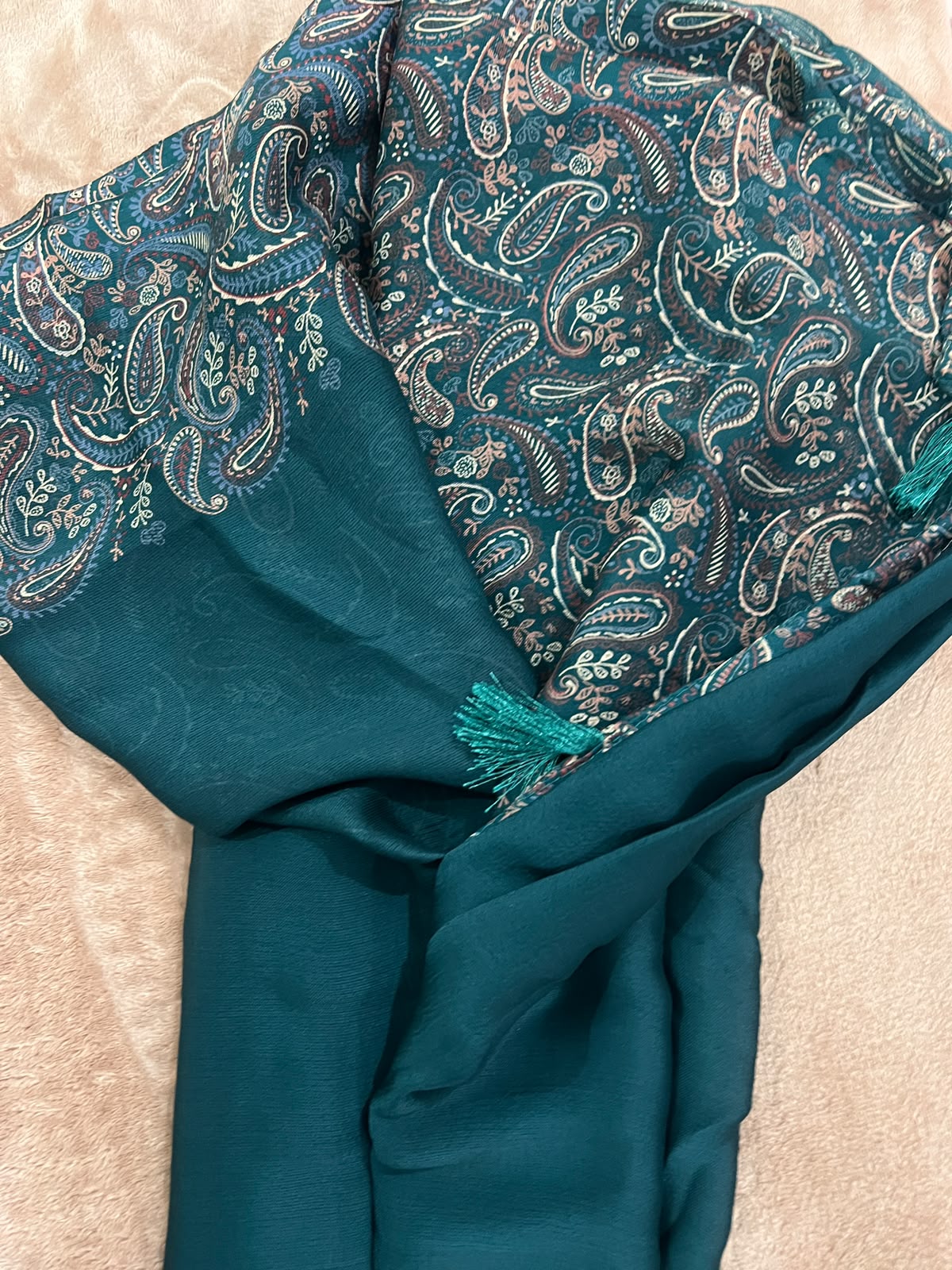 Teal green saree flat lay showing large-scale multicolour Kashmiri paisley print on pallu with silk tassels